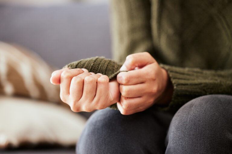 Woman pulling at her sleeve nervously