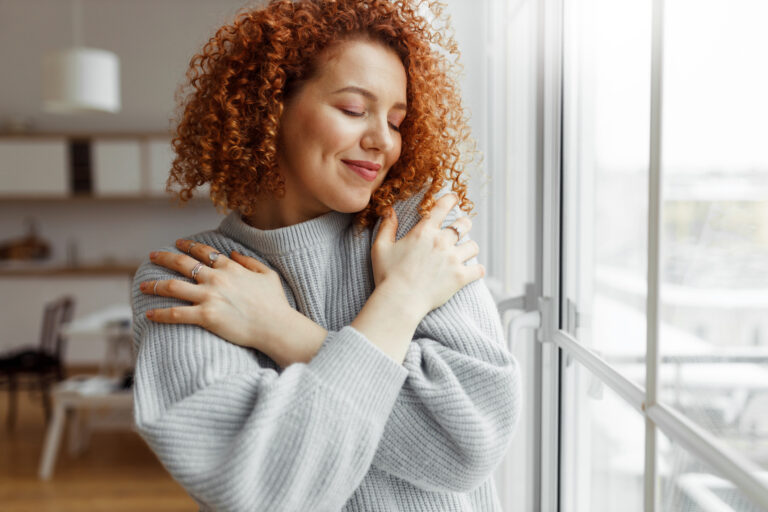 Young woman hugging herself as a sign of self love