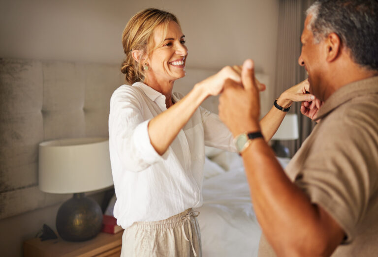 Happy mature couple dancing in a hotel room