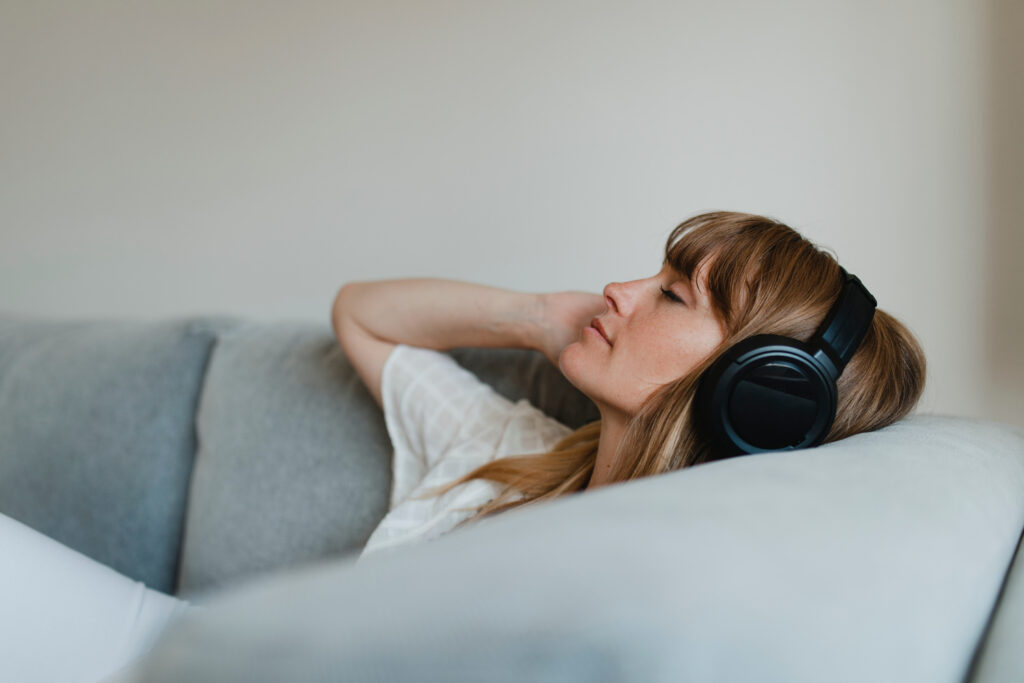 Woman listening to music on the couch after a PTSD therapy session