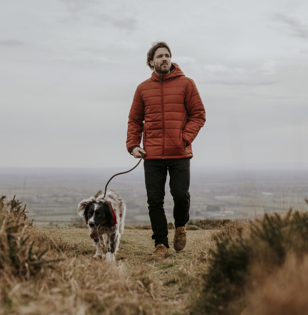 Man walking dog on hill photo