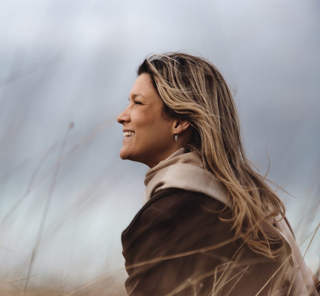 Happy woman day dreaming during autumn day in tall grass. Photographed in medium format. Copy space.